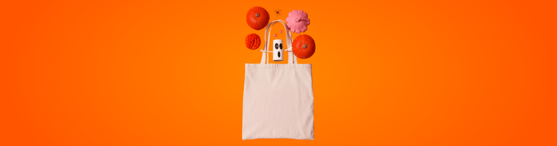 Canvas tote bag on bright orange background with pumpkins, pink pumpkin, ghost decoration and spider – Halloween tote bag banner.