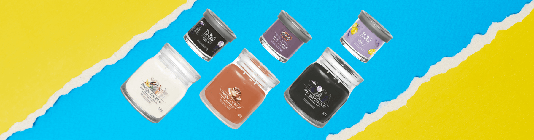 Yankee Candle new scents banner with Signature Tumbler jars and votives arranged diagonally on a bright blue and yellow torn-paper background.