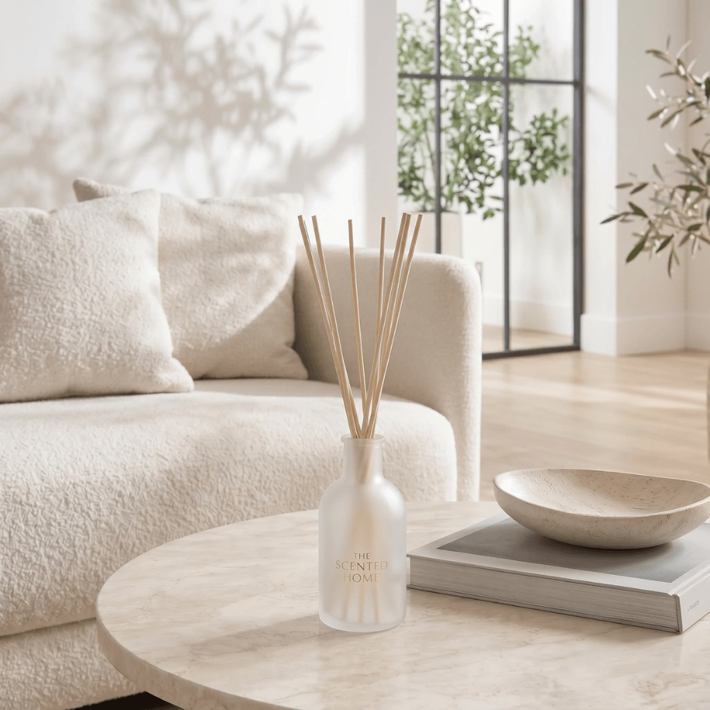 The Scented Home reed diffuser styled on a marble coffee table in a bright neutral living room