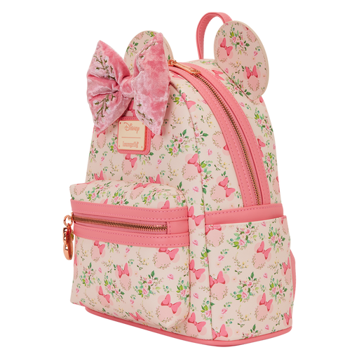 Angled view of the Loungefly Disney Minnie Mouse floral mini backpack showing the floral print, pink trim, velvet bow and gold zip.