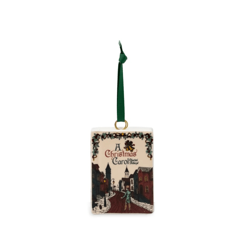 A Christmas Carol ceramic book Christmas tree decoration featuring an illustrated Victorian street scene and green hanging ribbon