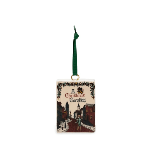 A Christmas Carol ceramic book Christmas tree decoration featuring an illustrated Victorian street scene and green hanging ribbon