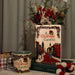 Large A Christmas Carol ceramic book vase filled with winter foliage; mug and holiday décor nearby
