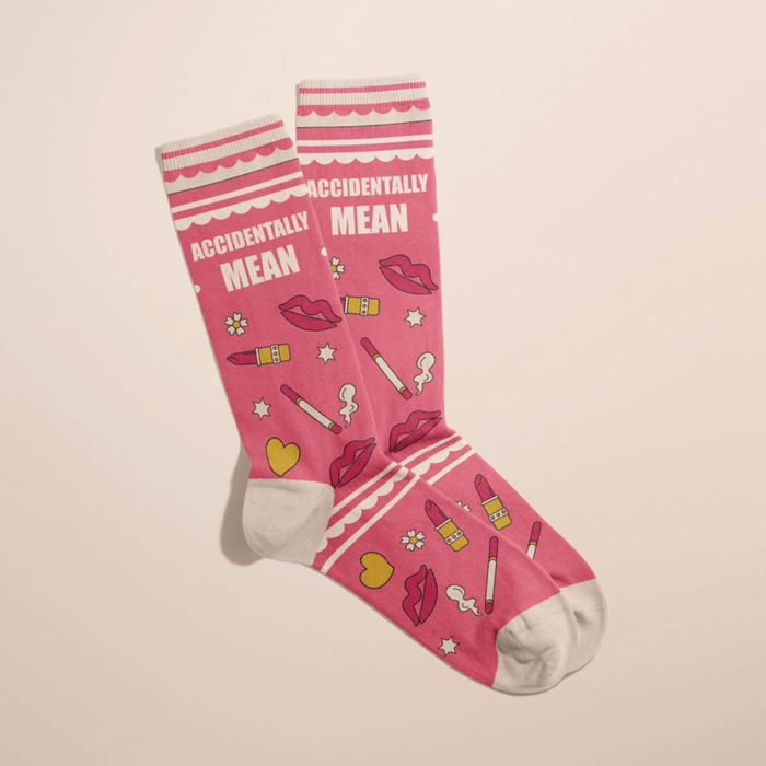 Angled view of pink Accidentally Mean women’s crew socks with cheeky beauty-themed doodles