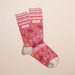 Angled view of pink Accidentally Mean women’s crew socks with cheeky beauty-themed doodles