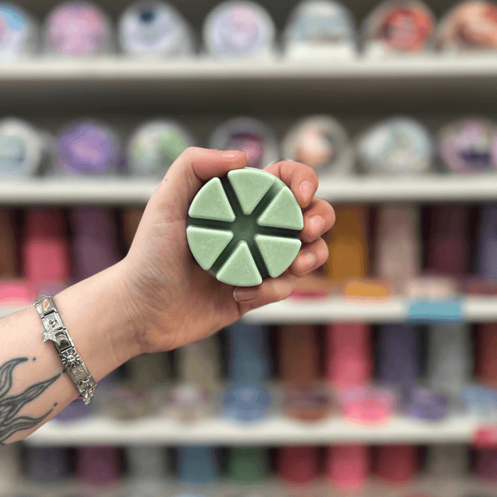 Alfresco Afternoon wax melt segments held in hand with colourful wax melt display in the background