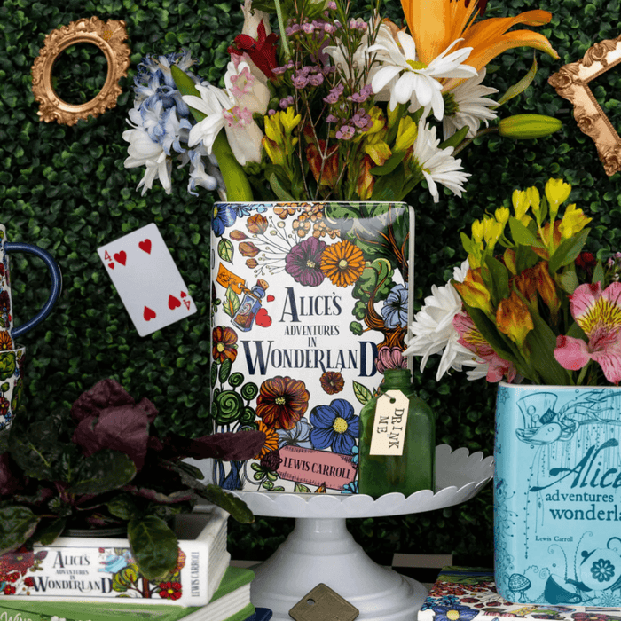 Ceramic Alice’s Adventures in Wonderland vase holding daisies and lilies