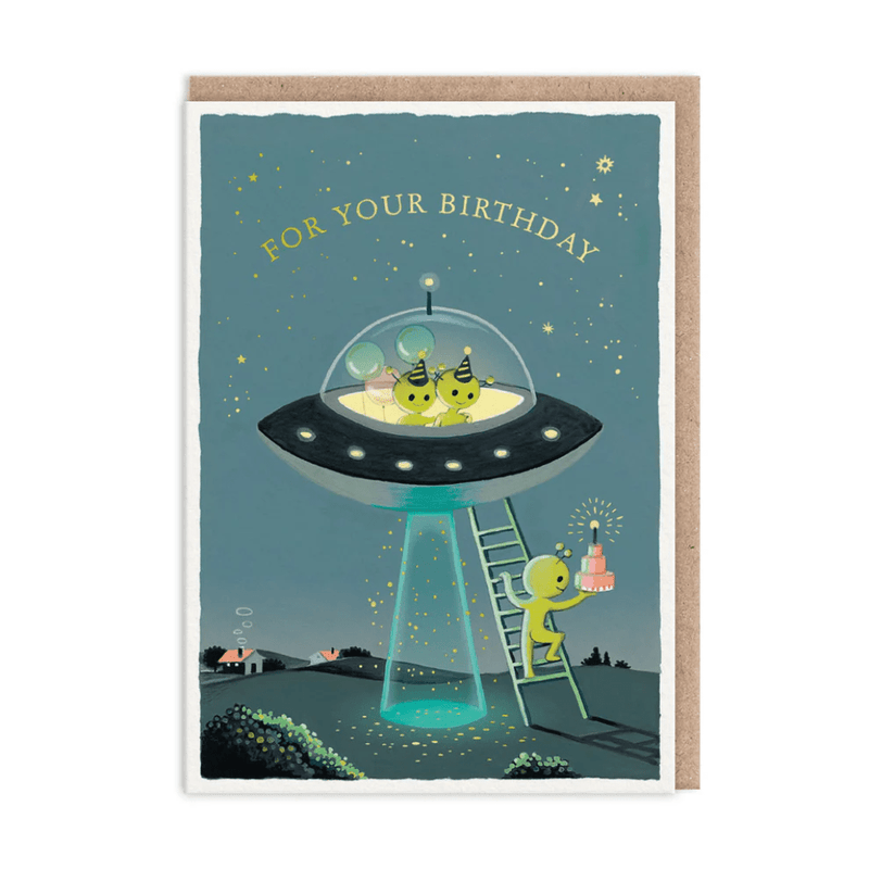 Birthday greeting card showing green aliens in party hats inside UFO; one climbs ladder with cake under starry sky
