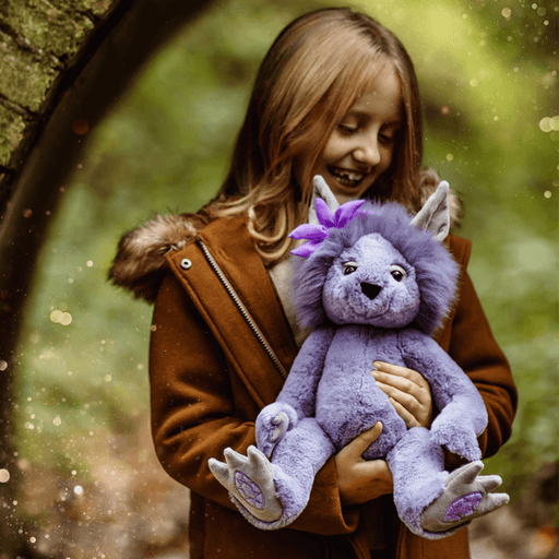 Amethyst Boo Charlie Bears Bearhouse crystal troll plush being held outdoors, showing the lilac fur, purple flower and crystal foot pads