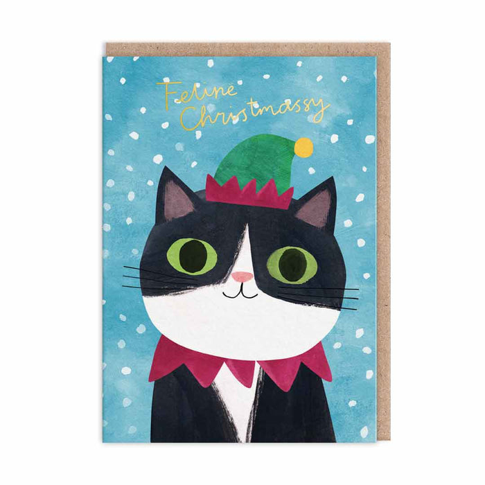 Festive Christmas card with tuxedo cat wearing green elf hat on snowy blue background, gold-foil Feline Christmassy text; A6, blank inside, brown kraft envelope