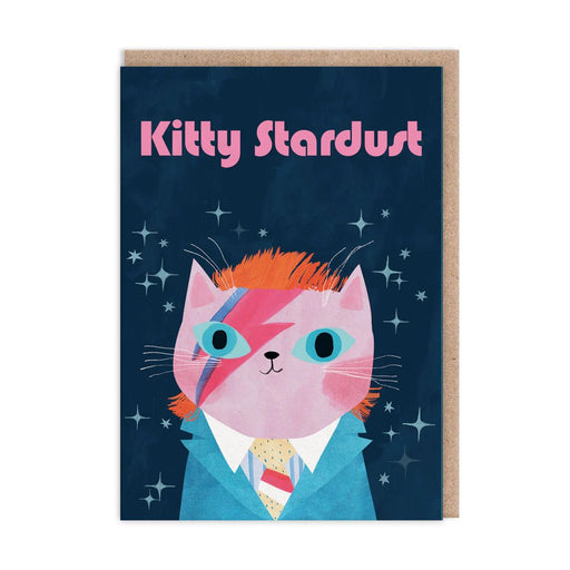 Navy greeting card with pink cat in blue suit and lightning-bolt face paint, starry background, text “Kitty Stardust”; A6, blank inside, kraft envelope by Angie Rozelaar