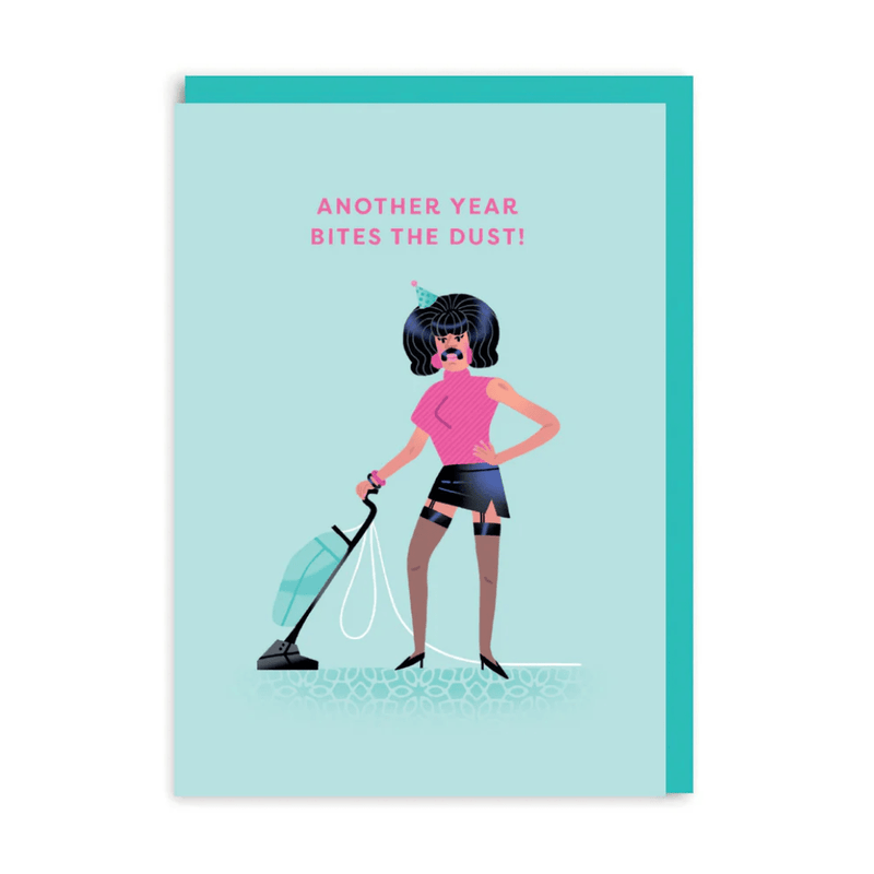 Birthday greeting card parody of rock singer vacuuming in drag, caption “Another Year Bites The Dust!” on teal background
