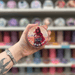 Arabian Princess wax melt pot held in hand with colourful wax melt display in the background