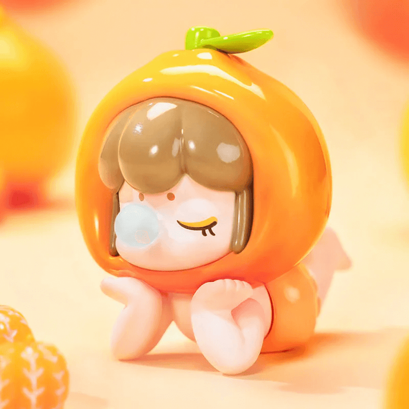 Orange-helmet Baby Nanci dozing on tummy, glossy peel finish – Fruits Series Blind Box
