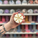 Baby Powder wax melt segments held in hand with colourful wax melt display in the background