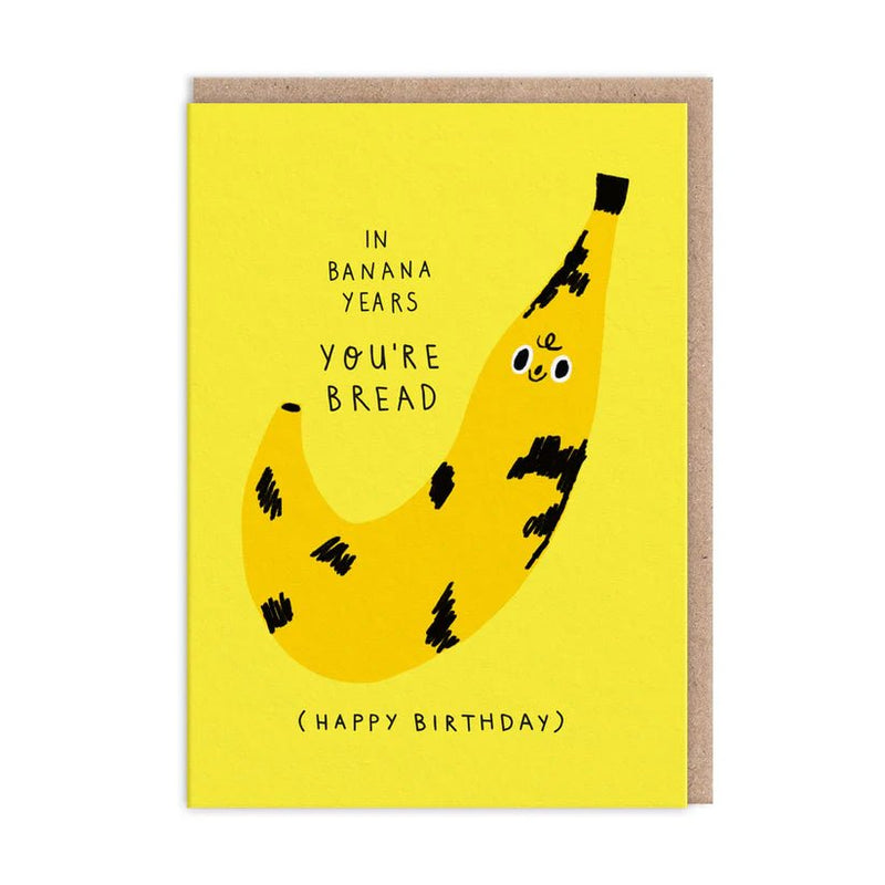 Bright yellow birthday card with smiling speckled banana; text reads In banana years you’re bread; A6 with kraft envelope
