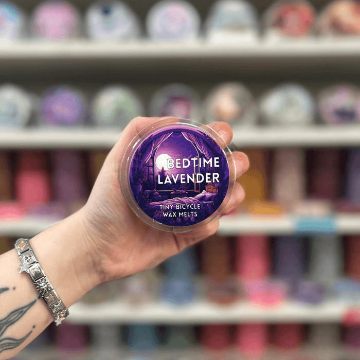 Bedtime Lavender wax melt pot held in hand with colourful wax melt display in the background