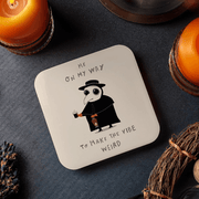 Betiobca plague doctor coaster shown in a dark lifestyle setting with candles and the phrase Me on my way to make the vibe weird