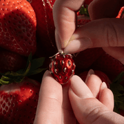 Bill Skinner red enamel strawberry locket held in hand