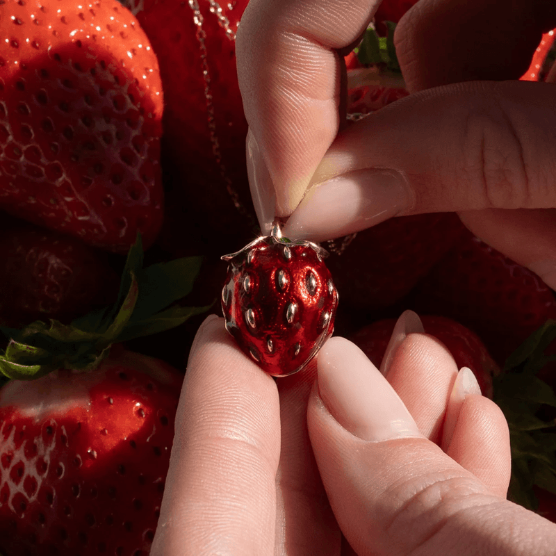 Bill Skinner red enamel strawberry locket held in hand