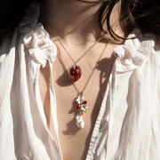 Bill Skinner Strawberry and Hanging Mouse necklace worn layered with a separate red strawberry pendant necklace