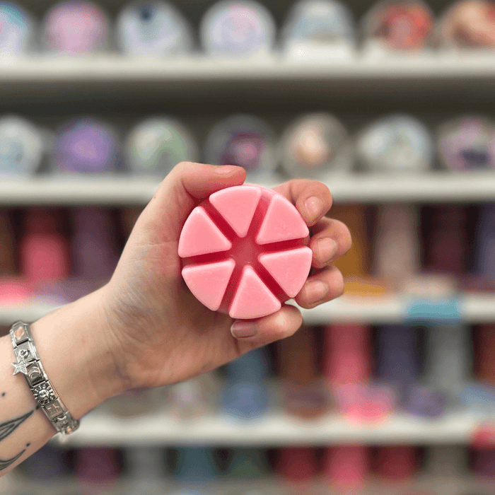 Birthday Cake wax melt segments held in hand with colourful wax melt display in the background