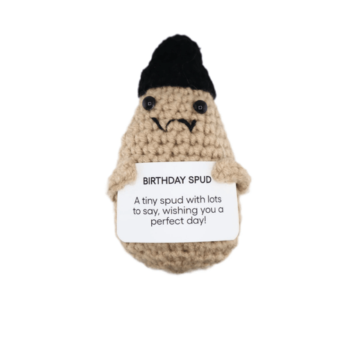 Crochet Birthday Spud potato decoration wearing a black hat and holding a birthday message card on white background