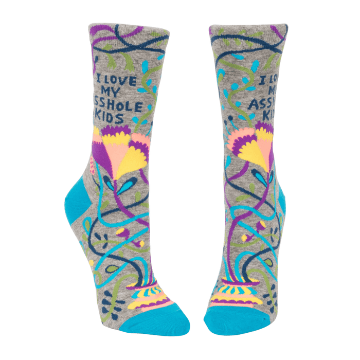 Front view of Blue Q women’s crew socks in grey with teal toe and heel, bold floral vines and the slogan I love my asshole kids