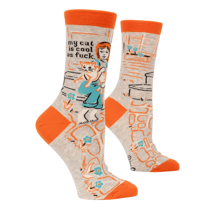 Front view of Blue Q women’s crew socks in oatmeal with orange cuffs and toes, retro illustration of a girl holding a ginger cat