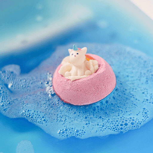 Bomb Cosmetics Born to be a Unicorn Bath Blaster floating and fizzing in the bath, creating bright blue water