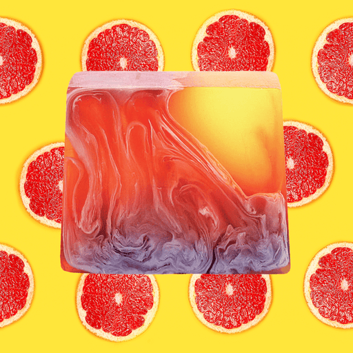 Bomb Cosmetics Caiperina Soap Slice styled on a bright yellow background with sliced grapefruit