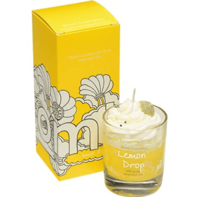 Bomb Cosmetics Lemon Drop piped scented candle—yellow wax with whipped top and glitter lemon slice beside sunny yellow gift box.