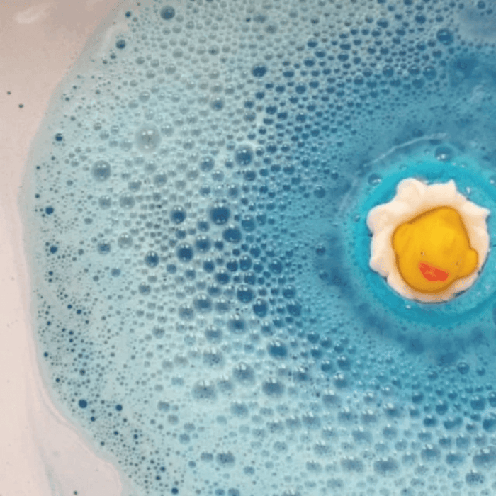 Bomb Cosmetics Pool Party Bath Blaster fizzing in the bath creating blue water with a duck topper