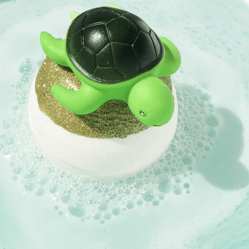 Bomb Cosmetics Turtle Chill Bath Blaster fizzing in the bath with a turtle topper and pale blue water