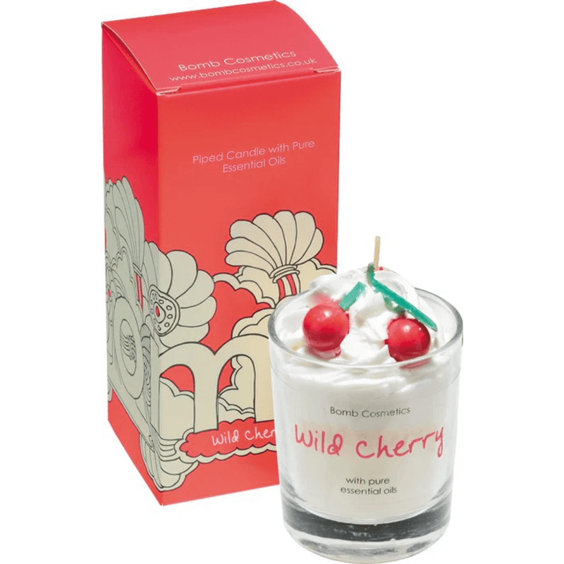 Bomb Cosmetics Wild Cherry piped scented candle in glass jar, topped with wax cherries, beside red gift box.