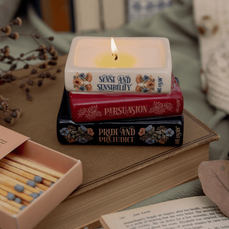 Lit Jane Austen book stack candle featuring Pride and Prejudice Persuasion and Sense and Sensibility
