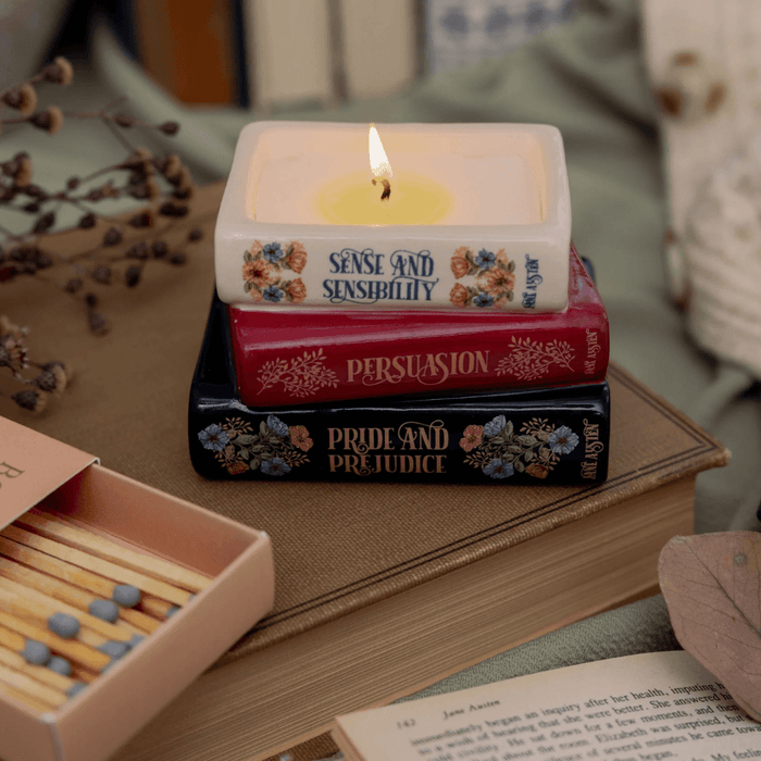Lit Jane Austen book stack candle featuring Pride and Prejudice Persuasion and Sense and Sensibility
