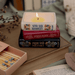 Lit Jane Austen book stack candle featuring Pride and Prejudice Persuasion and Sense and Sensibility
