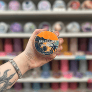Brazilian Summer wax melt pot held in hand with colourful wax melt display in the background