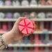 Bubblegum wax melt segments held in hand with colourful wax melt display in the background