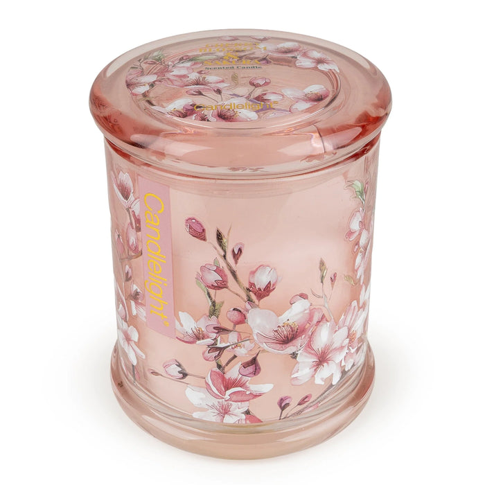 Angled view of Candlelight Cherry Blossom & Sakura large lidded glass jar candle with matching pink lid and blooms.