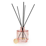 Candlelight Cherry Blossom & Sakura reed diffuser in blush pink glass bottle with black reeds on a white background.