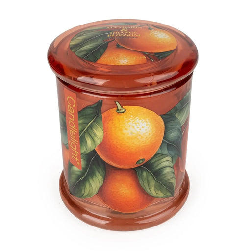 Angled view of Candlelight Mandarin & Orange Blossom large glass lidded jar candle in orange glass with mandarin and leaf design.