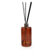 Candlelight Mandarin & Orange Blossom reed diffuser in ribbed amber glass bottle with black reeds on a white background.