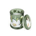 Candlelight White Poppy & Sage large glass lidded jar candle shown open, green glass with white poppy floral design and lid beside.