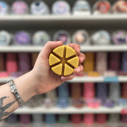 Caramel Latte wax melt segments held in hand with colourful wax melt display in the background