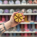 Caramel Latte wax melt segments held in hand with colourful wax melt display in the background