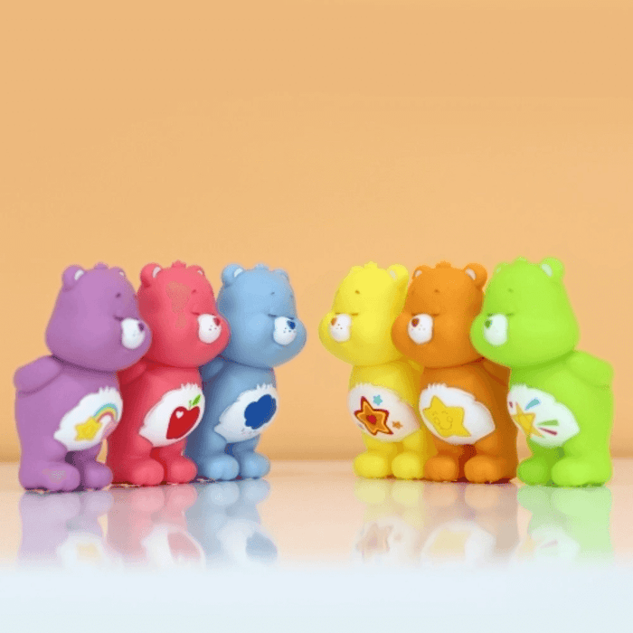 Care Bears mini figures arranged in two rows facing each other, orange background