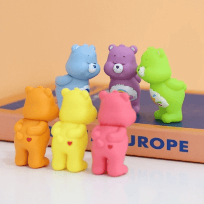 Care Bears mini figures grouped together in a lifestyle scene with mixed front and back views