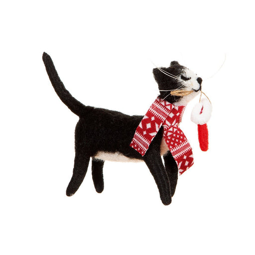 Side view of a handmade felt cat ornament with red knit scarf and mini stocking in its mouth; freestanding festive tree decoration on white.